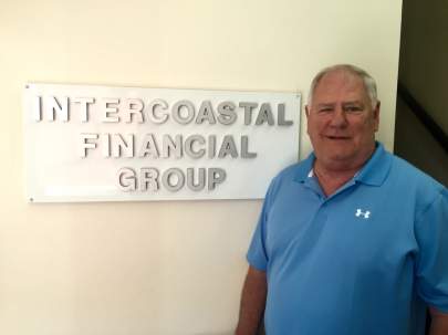 Jr. Bates standing next to the Intercoastal Financial Group sign